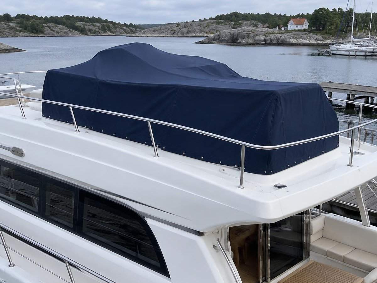 Nærbilde av skreddersydd marineblått flybridgetrekk over seter og styrekonsoll på flybridgen