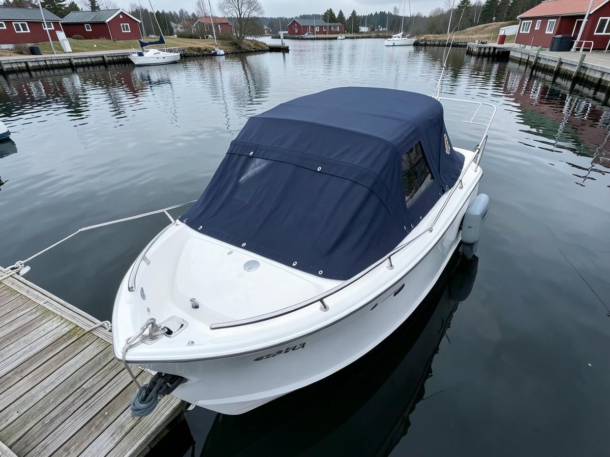 Tildekket motorbåt ved brygge