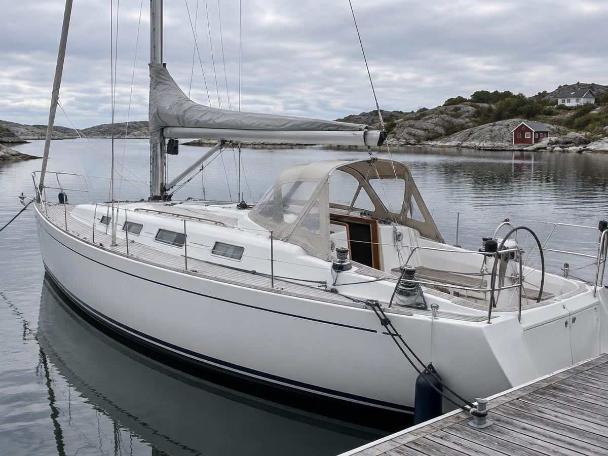 Seilbåt ved brygge med skreddersydd sandfarget sprayhood over nedgangen i cockpiten